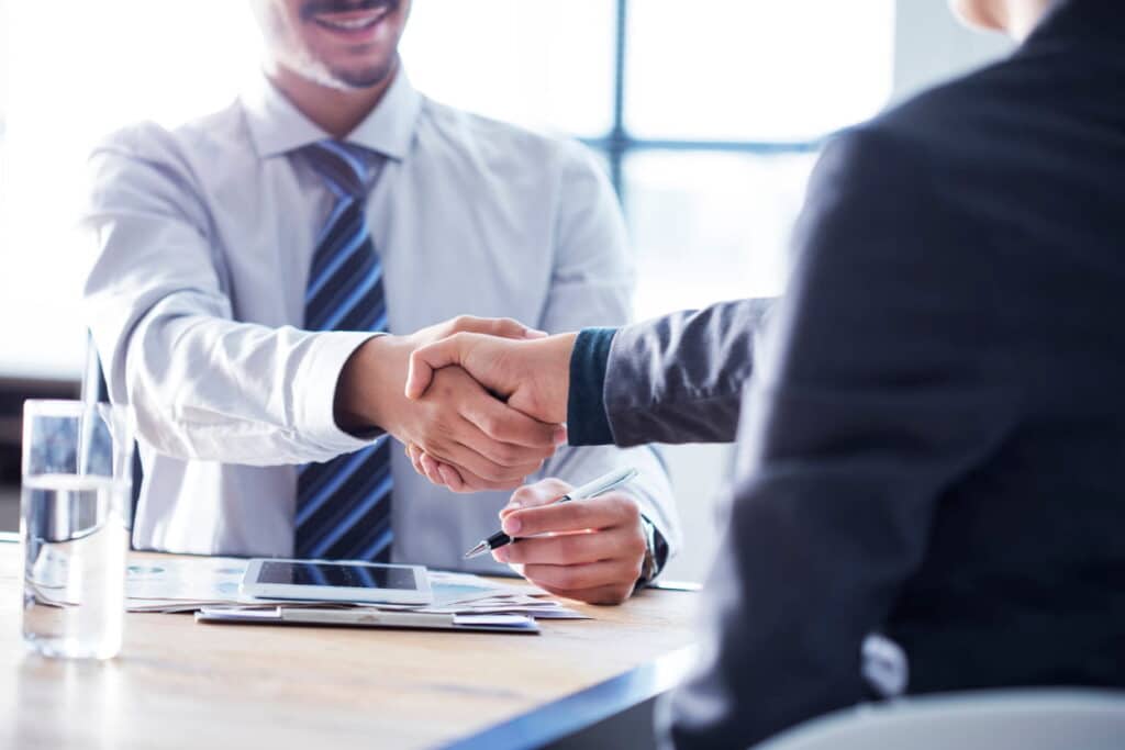 Property solicitor shaking hands with client following restrictive covenant indemnity insurance agreement